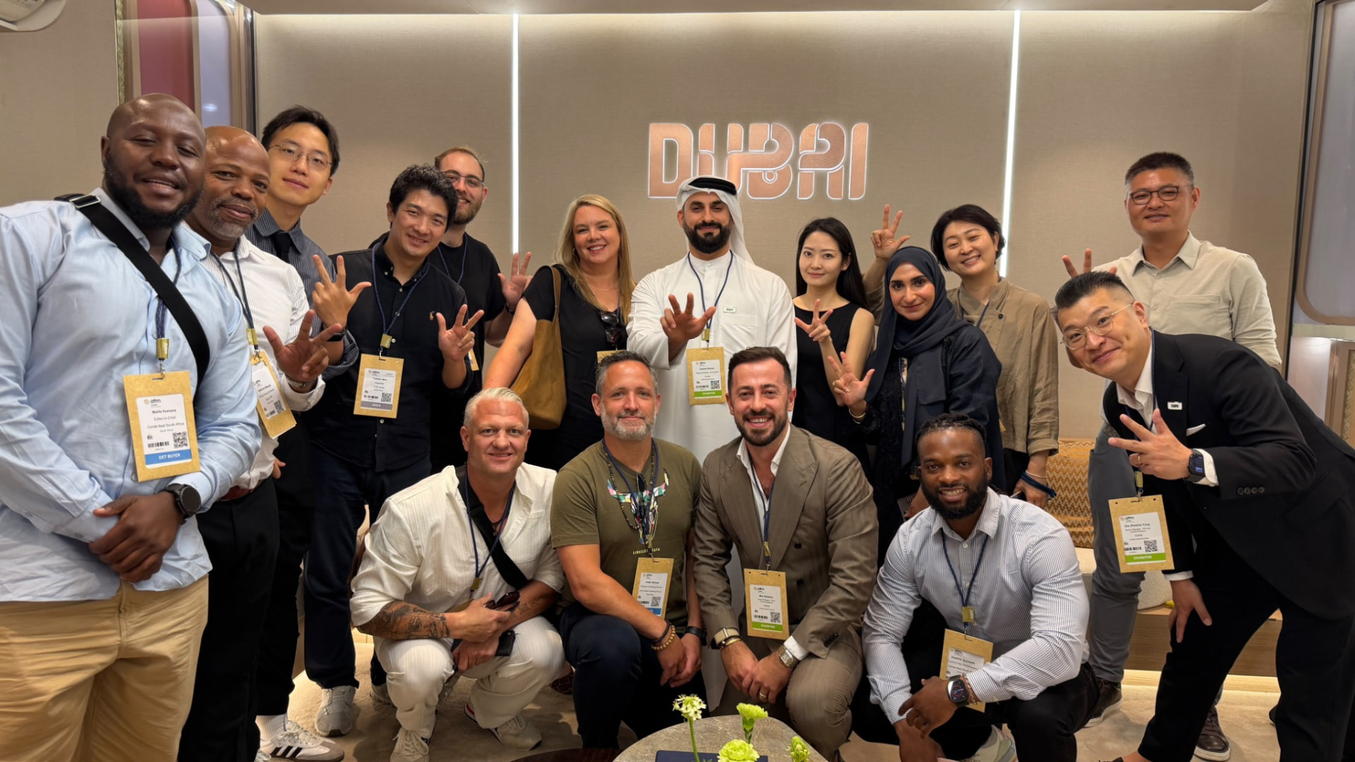 A diverse group of business delegates with lanyards posing together at a Dubai networking event